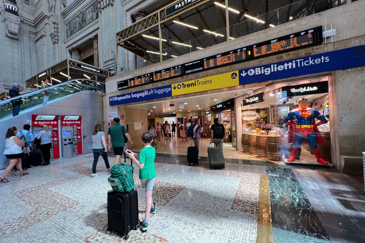 Child carrying luggage through Italian train station