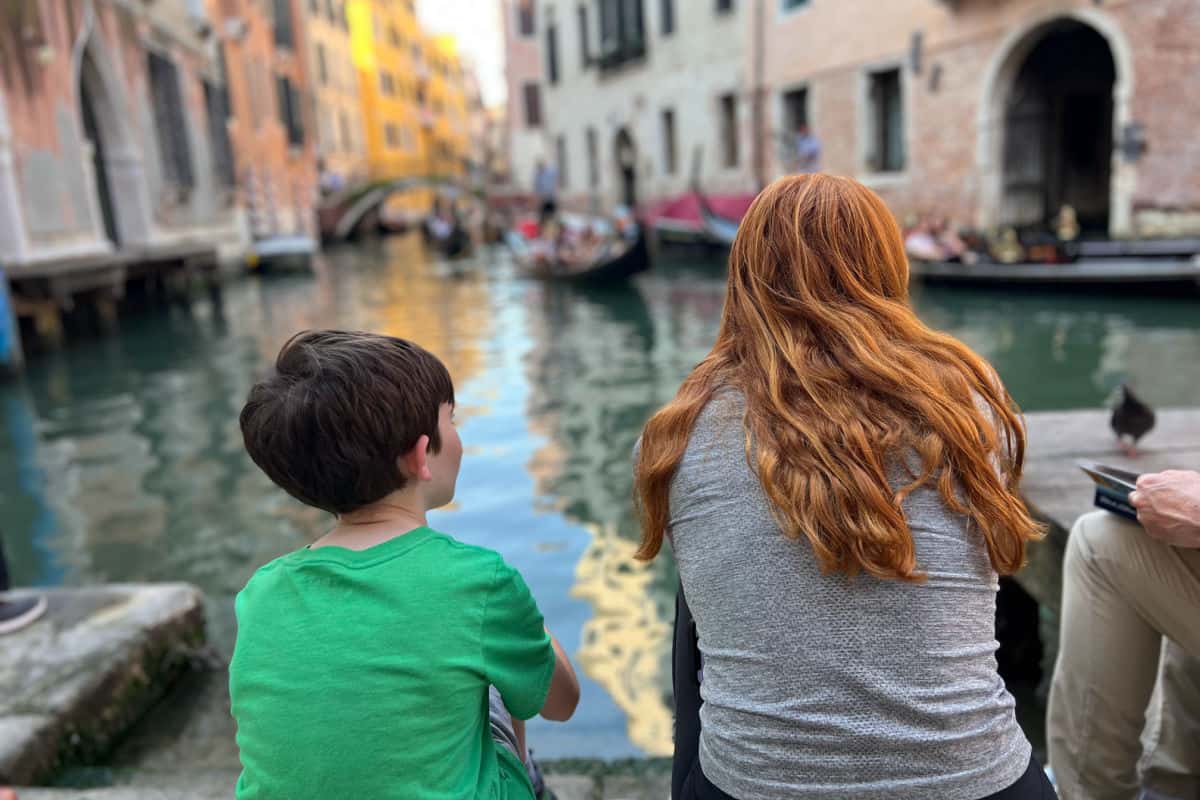 Kids watching gondolas in Venice Italy